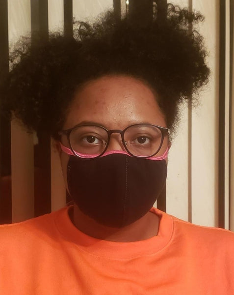 African American teenage girl wearing black face mask.